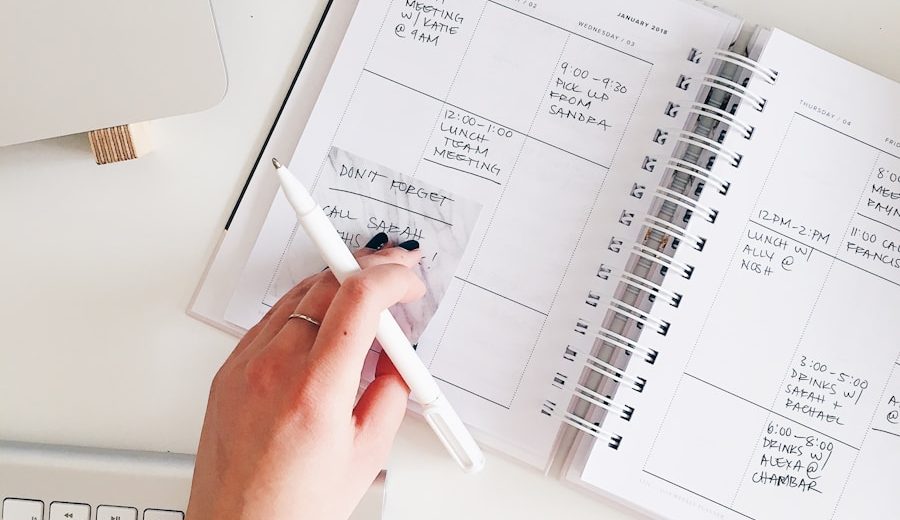 person holding notepad and pen flat lay photography