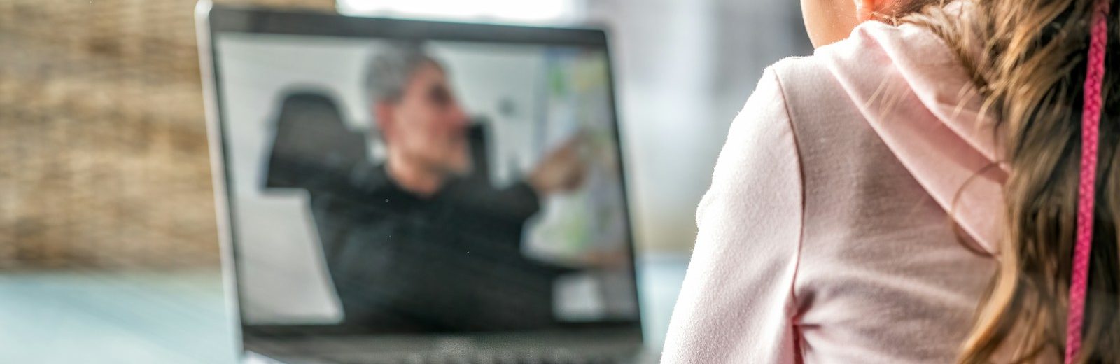 woman in pink long sleeve shirt sitting in front of macbook pro